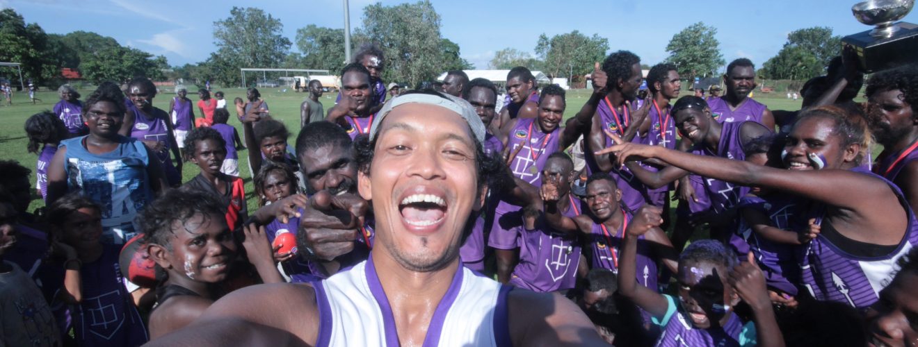 Irawan posing in front of the Tikaliru Dockers Tiwi Islands AFL Grand Final 2018