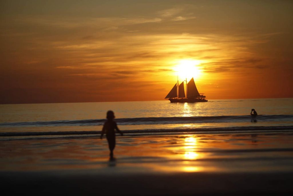 Silhouette of the sailing boat on sunset and my girl
